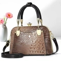 Close-up of brown crocodile pattern handbag with elegant diamond clasp and gold accents - Dark Khaki
