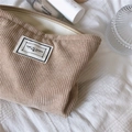Close-up of beige corduroy makeup bag with 'TIME TO PARTY' label and zipper detail - Khaki