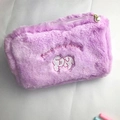 Close-up of purple plush makeup bag featuring a pearl zipper and embroidered text - Purple Puppy