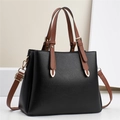 Sac Boston chic en cuir noir grainé avec poignées marron et détails dorés élégants - Noir