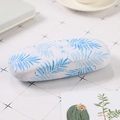 Portable hard shell glasses case with white fabric texture and blue palm leaf pattern - Floating Light Leaves