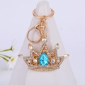Goldener Kronen-Schlüsselanhänger mit blauem Edelstein und Kristallen auf Stativ - Blauer Edelstein-Stil