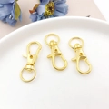 Trois fermoirs mousquetons dorés sur un plateau blanc avec fleurs décoratives - 32mm / Doré