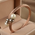 Macro detail of rose gold cable twist bangle featuring two lustrous white pearls on ends - Rose Gold/Steel