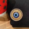 Luxuriöse blaue Evil Eye Brosche mit Goldplattierung und Kristallen auf schwarzem Stoff - Böser Blick Rund Gold Strass