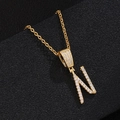 Macro detail of gold-plated letter N pendant with white zircon on black leather - Letter N