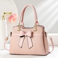 Pink lady handbag with large bow and geometric texture, handheld and shoulder bag style - Pink