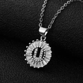 Macro shot of silver letter U pendant with cubic zirconia inlay on black leather - Silver Letter U