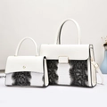 Close-up of white and black python-embossed faux leather handbag set with gold hardware - White