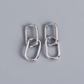 Dettaglio degli orecchini in argento S925 con maglie ovali intrecciate su sfondo grigio - Oro Bianco