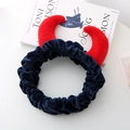 Détail du bandeau en peluche à cornes de diable rouges sur un livre, rouge et bleu marine - Bleu marine