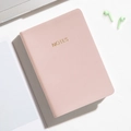 Portable A6 pink leather pocket notebook with gold Notes lettering on white desk - Milk Tea Pink