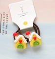 Close-up of cute yellow house cartoon charms on elastic hair ties for kids - Christmas Hut