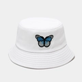 Dettaglio del ricamo farfalla blu su un cappello a secchiello in cotone bianco pulito - Bianco