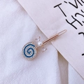 Dettaglio del fermaglio per capelli dorato con ciondolo a lecca-lecca in cristallo blu e bianco - Blu