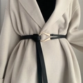 Minimalist black horsebit leather belt for women tied over a white coat with gold buckle - 124cm / Black