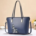 Dettaglio borsa tote blu scuro con ricamo floreale bianco e finiture metalliche dorate - Blu