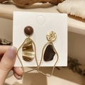 Detalle de pendientes asimétricos esmaltados con agujas de plata S925 y textura dorada - Pendientes geométricos asimétricos dorados (pin de plata 925)