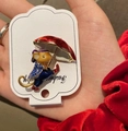 Dettaglio della spilla a forma di topo con strass blu e ombrello rosso su carta bianca - Topo Blu con Ombrello