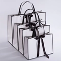 White paper gift bags with black trim and ribbon handles in four different sizes - White Base Black Border With Bow Rivet Style / Small 28*20*10CM