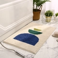 Modern geometric bath mat in blue and cream on marble floor next to a white bathtub - 40x60cm / Sunrise Beige