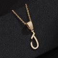 Macro shot of gold letter J pendant necklace with micro-pave white zircon settings - Letter J