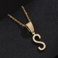 Detailed close-up of golden letter S pendant with micro-pave zircons on black leather - S