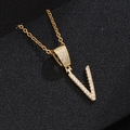 Macro shot of gold V letter pendant with micro-paved zircons on a fine chain - Letter V