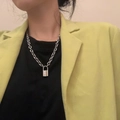 Collana a catena d'argento con ciondolo a lucchetto indossata sopra camicia nera e giacca - Pendente a Lucchetto Standard / Argento