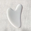 White heart-shaped resin gua sha tool for facial and body massage on grey background - White Heart