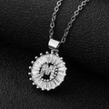 Macro view of silver letter M pendant with cubic zirconia inlay and baguette stones - Silver Letter M