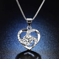 Macro shot of silver heart pendant with brilliant central stone and pavé setting details - Q021 Heart Sparkling 1ct