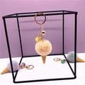 Detail of plush ice cream keychain with fluffy pompom cone and gold tassel charm - Beige