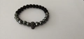 Men's 6mm frosted stone bead bracelet with a black skull charm on a white background - Skull Style / Black