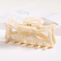 Close-up of cream marble texture hair claw clip with golden spring on a white tray - S141-3 Cream Marble