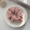 Detail of pink ribbed fabric scrunchie with soft knit texture on white ceramic tray - Pink
