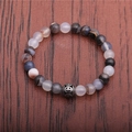 Striped agate beaded bracelet with a hollow geometric metal charm on a wooden surface - Grey Agate