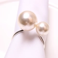 Elegant U-shaped silver napkin ring with two mismatched white pearls on white napkin - 18+25M Silver Finish White High-Gloss Pearl