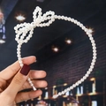 Detail of handmade faux pearl headband with elegant bow knot held by a hand - 20# Pearl Bow Style