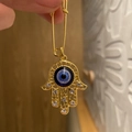 Hamsa-Hand-Brosche mit türkischem bösen Auge und weißen Strasssteinen in Gold-Finish - Hamsa Auge