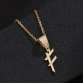 Close-up of golden zircon initial pendant necklace on a premium black textured display - Letter F