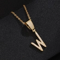 Macro view of gold pendant necklace with letter W inlaid with white zircon crystals - Letter W