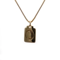 Detailed view of a gold rectangular copper pendant necklace with a circular accent - Letter O