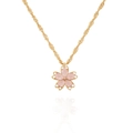 Makro-Detail eines Kirschblütenanhängers mit rosa Blütenblättern und Kristall an Goldkette - Rosa