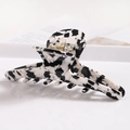 Close-up of a large marbled acetate hair claw clip with a black and white cow print texture - S138-8 Ink Wash