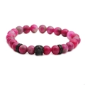 Bracciale di perle in pietra naturale rosa con teschio in metallo nero su sfondo bianco puro - Nero