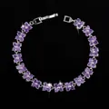 Close-up of purple zircon flower link bracelet with polished silver finish and fold-over clasp - 17.6cm / Purple