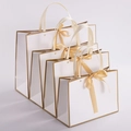 Set of four white paper gift bags with elegant gold trim and champagne silk bow ribbons - White Base Gold Border With Bow Rivet Style / Small 28*20*10CM