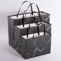 Three sizes of premium black marble pattern paper gift bags with reinforced metal rivets - Black Marble Rivet Style