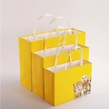 Yellow paper gift bag set with white rope handles and cute cartoon puppy prints - Cartoon Dogs Illustration Rivet Style